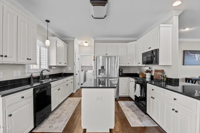 a kitchen with white cabinets and appliances