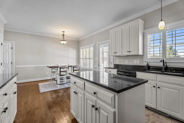 a kitchen with granite countertop a sink stove and cabinets