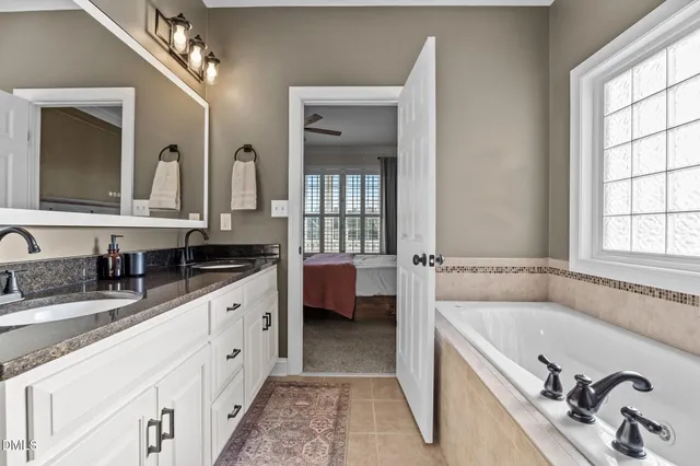 a spacious en suite bathroom with double sink and a large mirror
