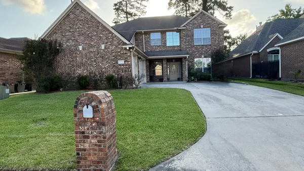 a view of a house with a yard and pathway