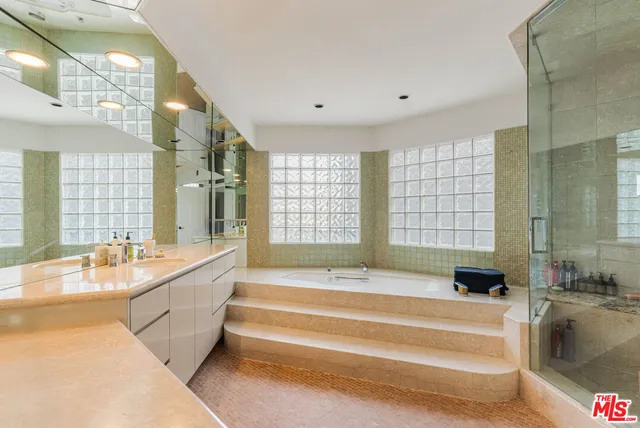 a bathroom with a tub shower vanity and a sink