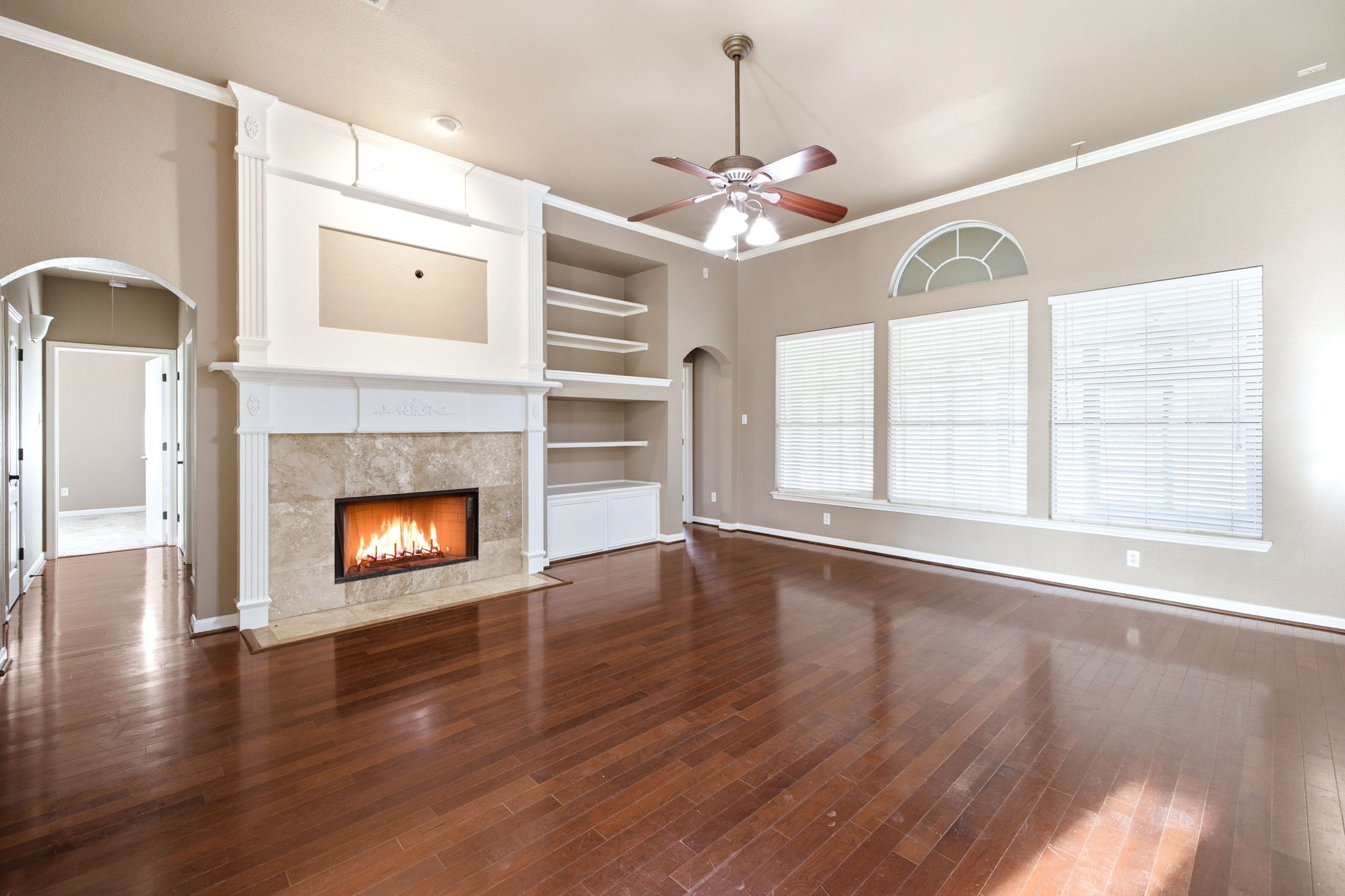 271 Rollin N Ranch Road Blanco, TX 78606 - Photo 15 of 40 A refined living space showcasing a beautiful fireplace, built-in shelving, and lustrous hardwood floors.