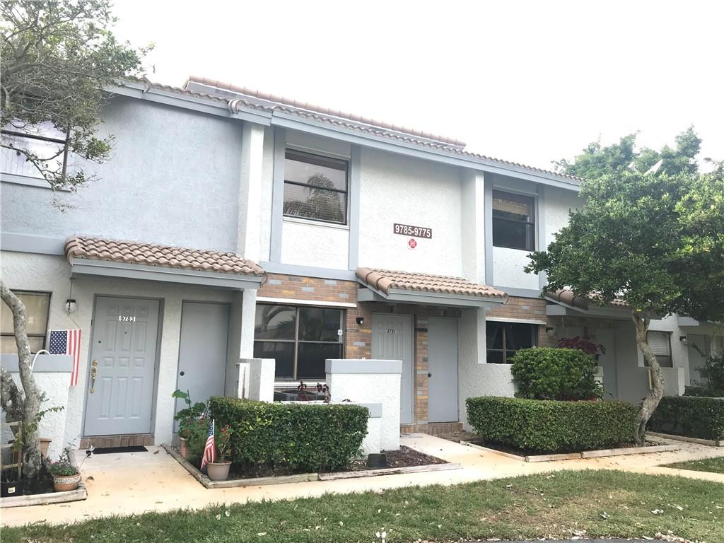 9781 Riverside Drive, Unit 653 Coral Springs, FL 33071 - Photo 1 of 19 a front view of a house with a yard and garage