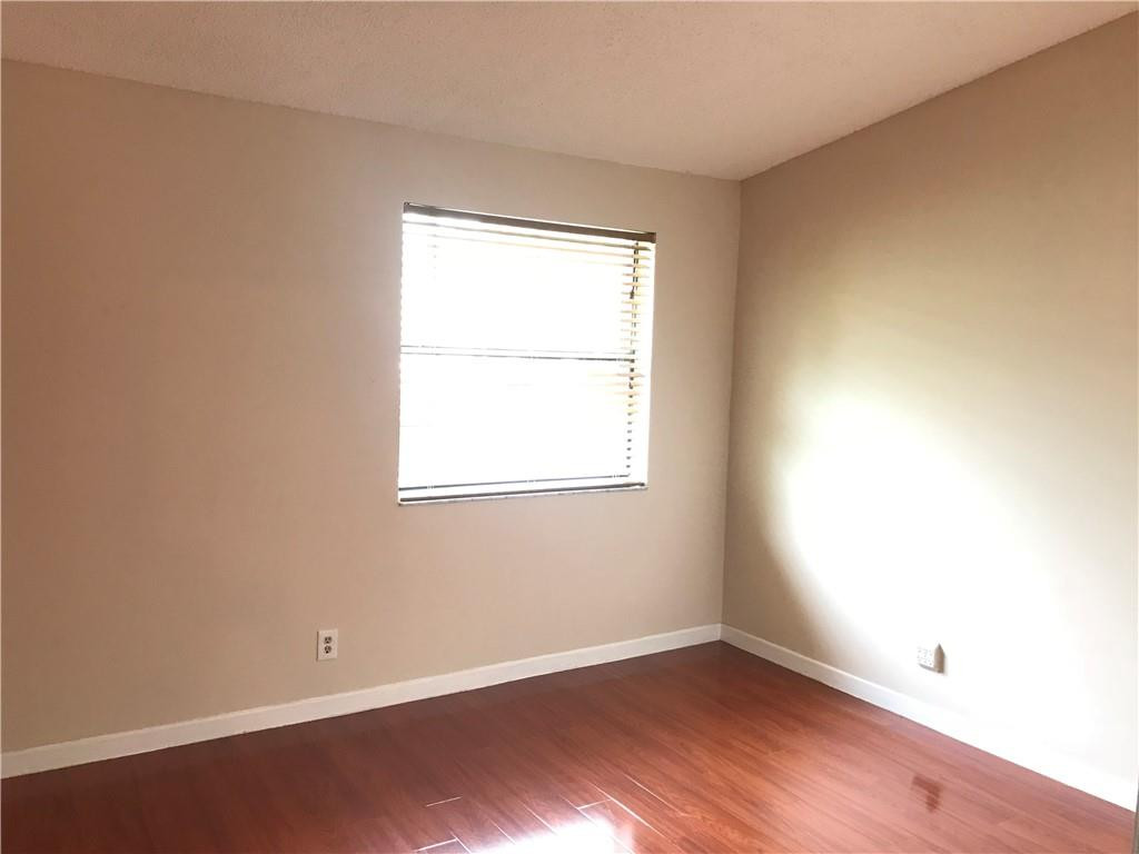 9781 Riverside Drive, Unit 653 Coral Springs, FL 33071 - Photo 12 of 19 an empty room with wooden floor and windows