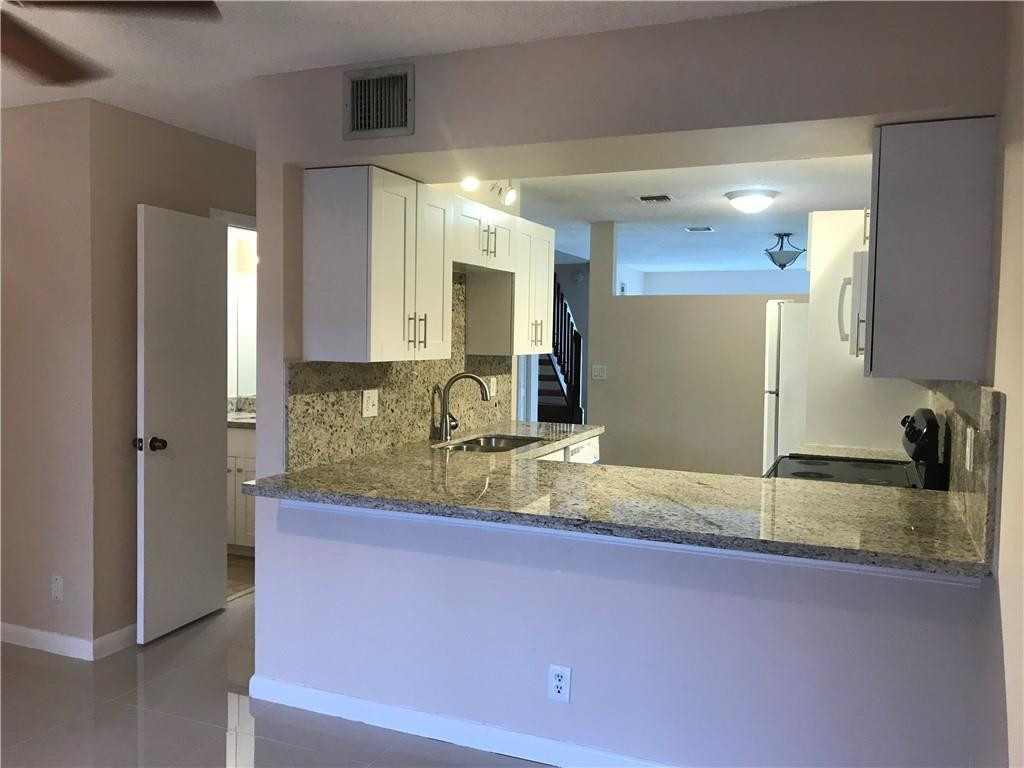 9781 Riverside Drive, Unit 653 Coral Springs, FL 33071 - Photo 6 of 19 a bathroom with a granite countertop sink and a mirror