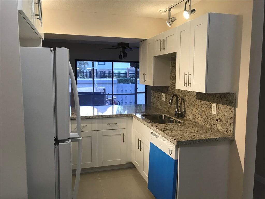 9781 Riverside Drive, Unit 653 Coral Springs, FL 33071 - Photo 7 of 19 a kitchen with a sink stove and refrigerator