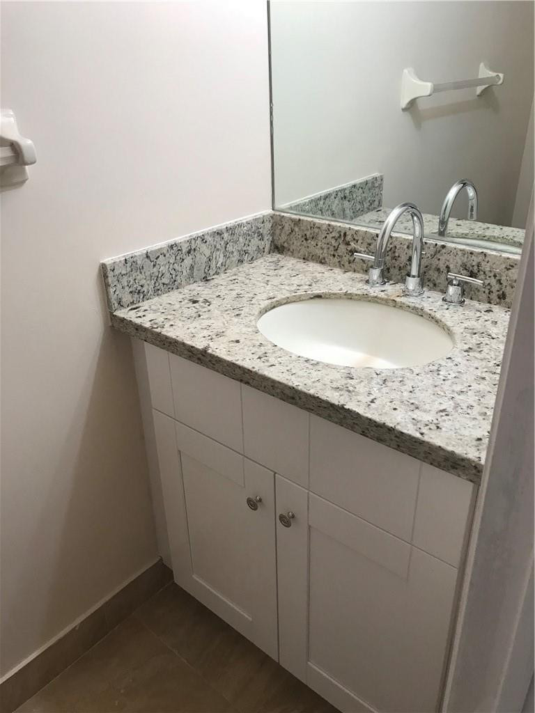 9781 Riverside Drive, Unit 653 Coral Springs, FL 33071 - Photo 9 of 19 a bathroom with a granite countertop sink and a mirror
