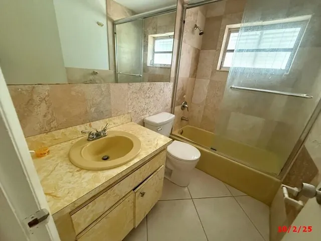 an empty room with windows and ceiling fan