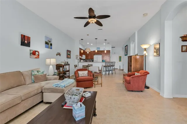 a living room with furniture kitchen view and a chandelier