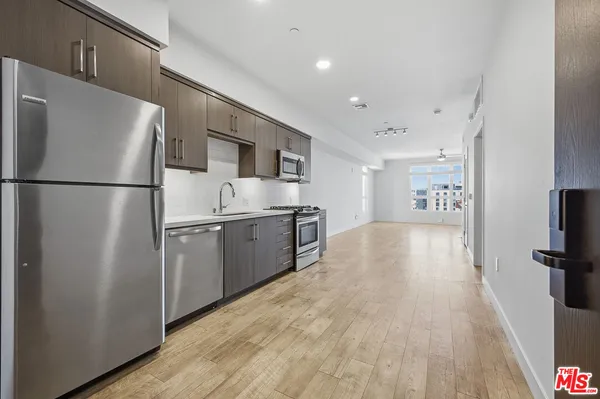 a kitchen with a refrigerator a sink and a microwave