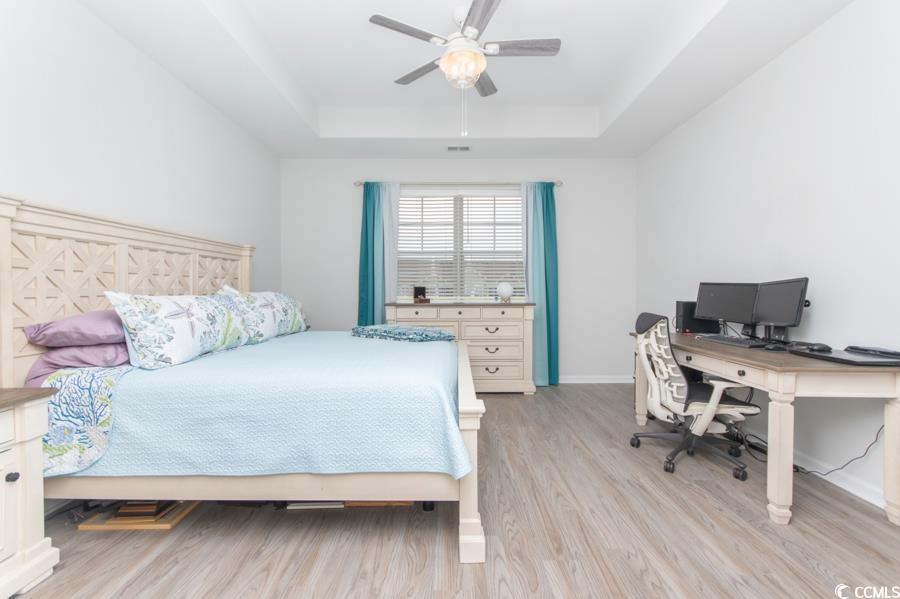 131 Machrie Loop, Unit A Myrtle Beach, SC 29588 - Photo 14 of 40 Bedroom with a tray ceiling, light hardwood / wood