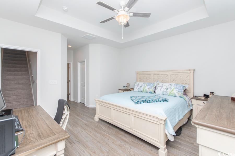 131 Machrie Loop, Unit A Myrtle Beach, SC 29588 - Photo 15 of 40 Bedroom featuring ceiling fan, a tray ceiling, and