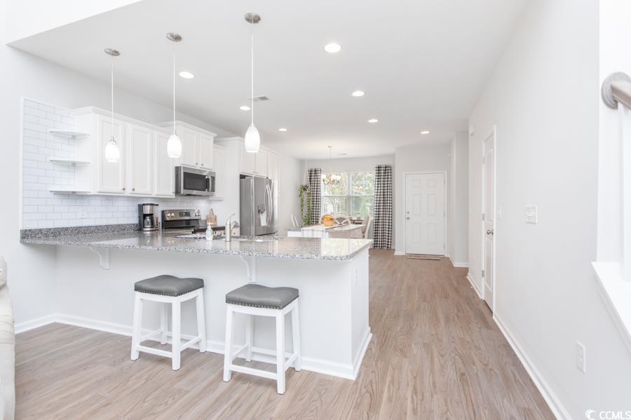 131 Machrie Loop, Unit A Myrtle Beach, SC 29588 - Photo 6 of 40 Kitchen featuring white cabinetry, kitchen peninsu