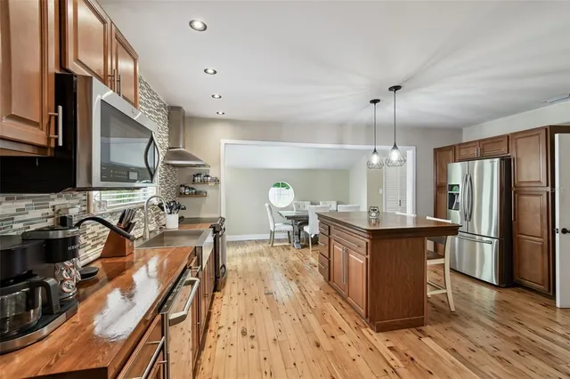 a kitchen with stainless steel appliances granite countertop a stove refrigerator and wooden floor