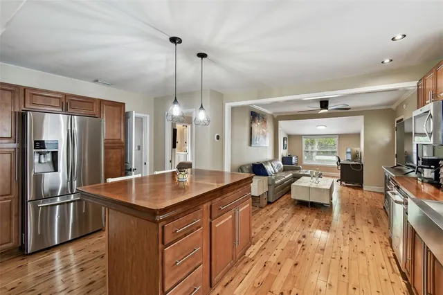 a kitchen with sink refrigerator and wooden floor