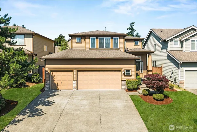 a front view of a house with a yard and potted plants