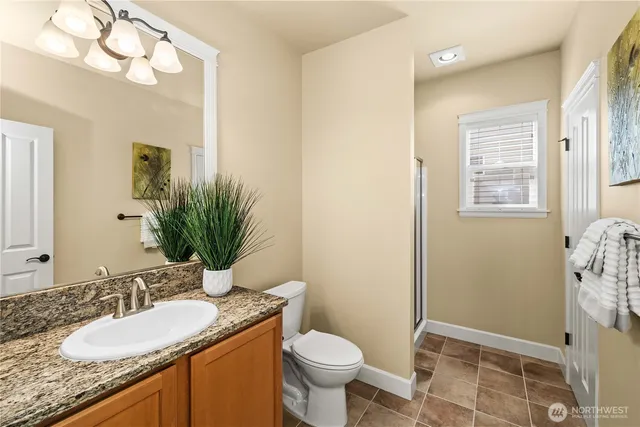 a bathroom with a granite countertop toilet sink and mirror