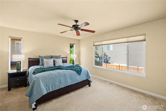 a spacious bedroom with a large bed and a chandelier