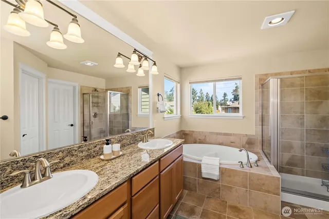 a spacious bathroom with a granite countertop tub sink and mirror