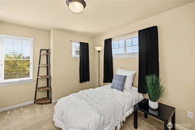 a bedroom with a bed and a potted plant