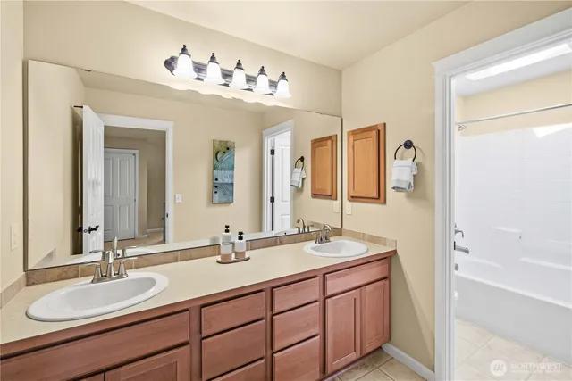 a bathroom with a double vanity sink mirror double and bathtub