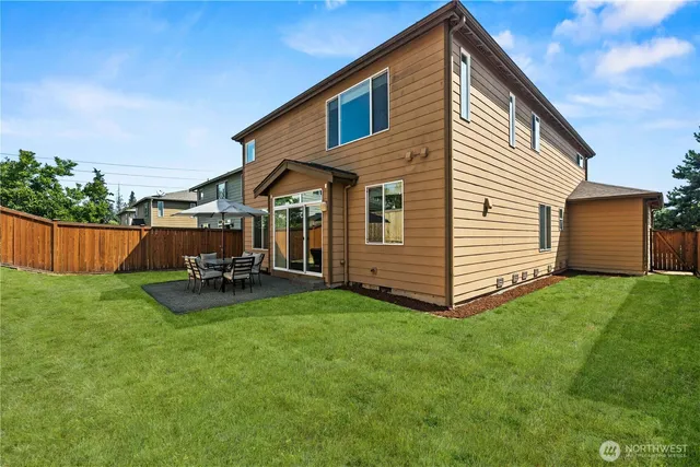 a view of backyard with barbeque grill and wooden fence