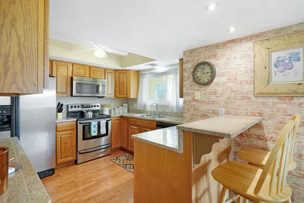 a kitchen with stainless steel appliances granite countertop a refrigerator and a stove top oven