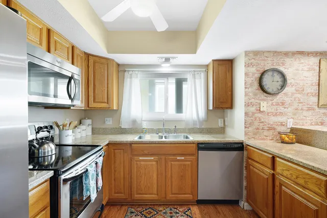 a kitchen with stainless steel appliances granite countertop a refrigerator and a stove top oven