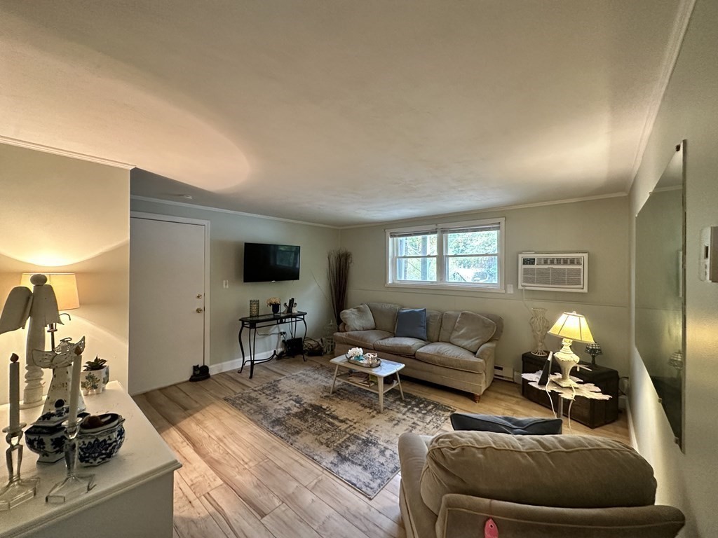 44 Burnap Road, Unit 1 Holliston, MA 01746 - Photo 2 of 17 a living room with furniture and a flat screen tv