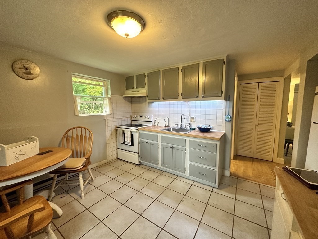 44 Burnap Road, Unit 1 Holliston, MA 01746 - Photo 6 of 17 a kitchen with a sink and wooden cabinets
