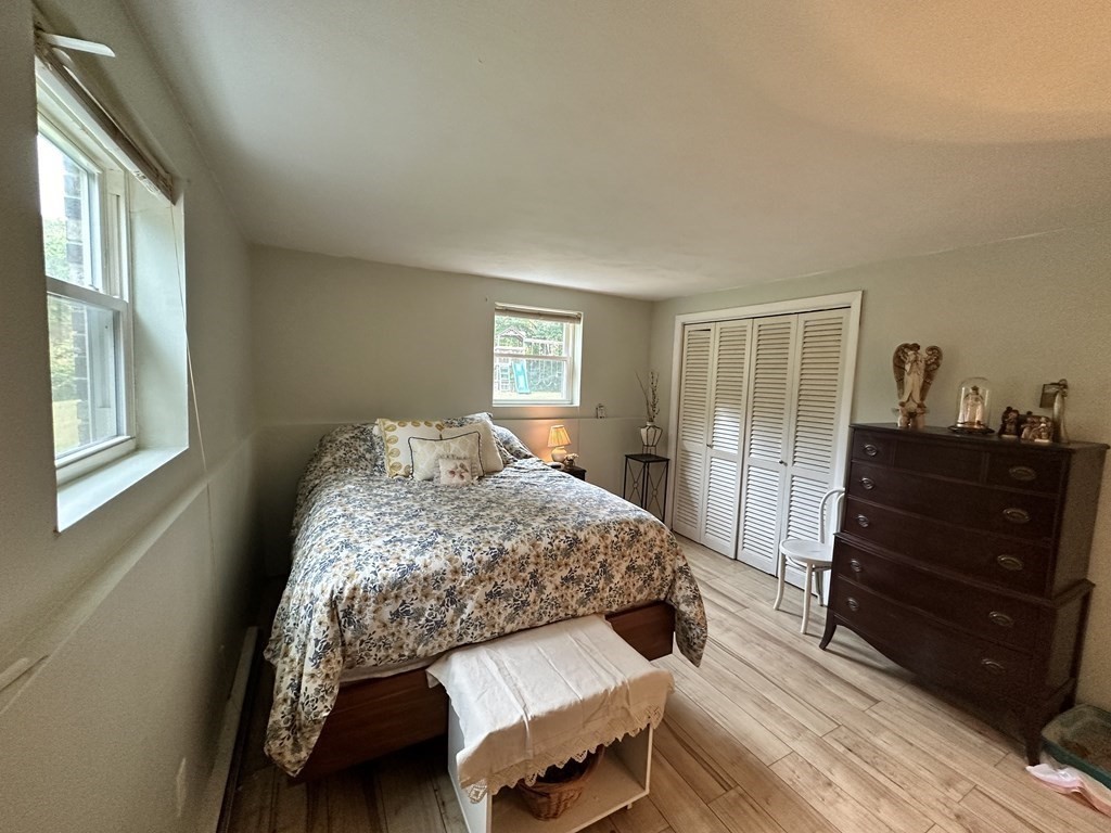 44 Burnap Road, Unit 1 Holliston, MA 01746 - Photo 7 of 17 a bedroom with a bed and wooden floor