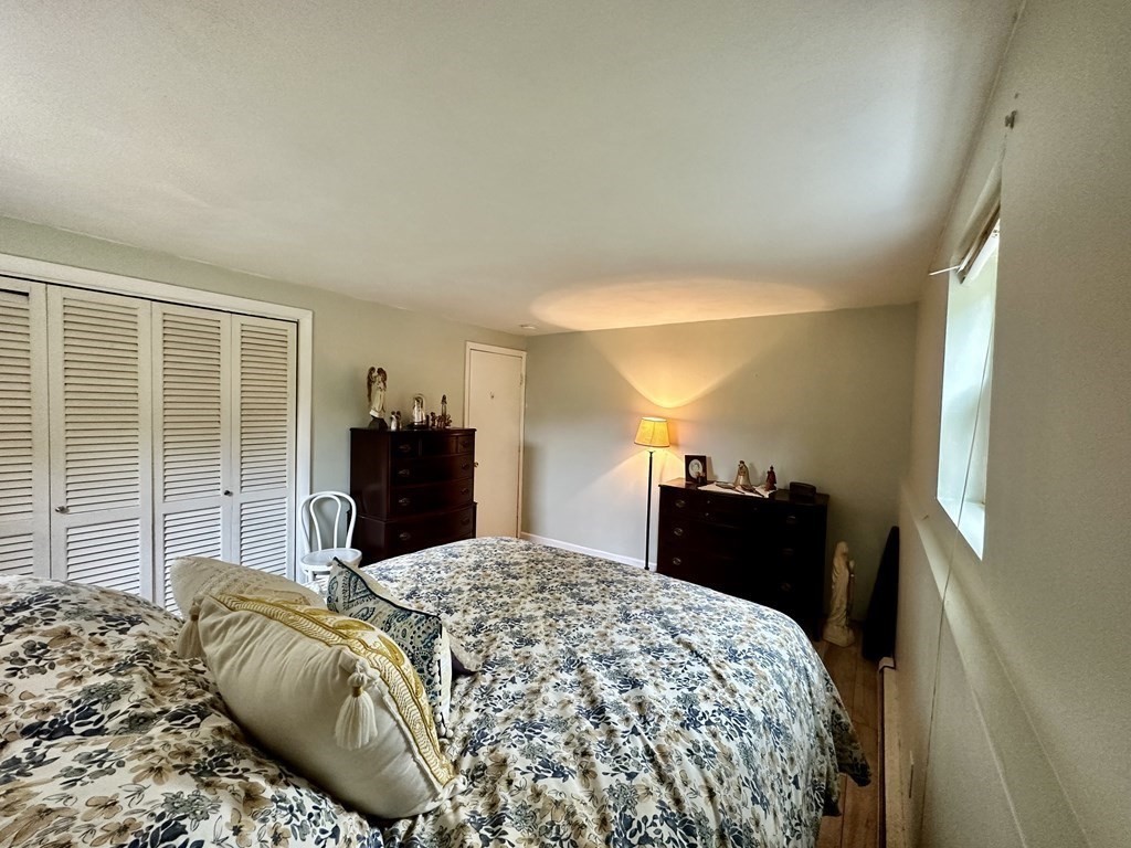 44 Burnap Road, Unit 1 Holliston, MA 01746 - Photo 8 of 17 a bedroom with a bed and dresser with mirror