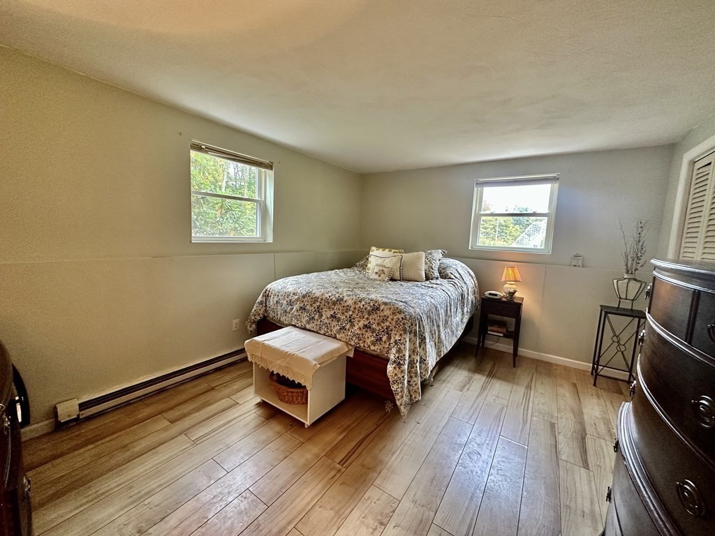 44 Burnap Road, Unit 1 Holliston, MA 01746 - Photo 9 of 17 a bedroom with a bed and wooden floor