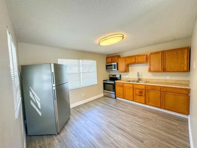 a kitchen with stainless steel appliances granite countertop a refrigerator and a stove top oven
