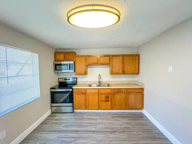 a view of a kitchen with wooden floor and a sink