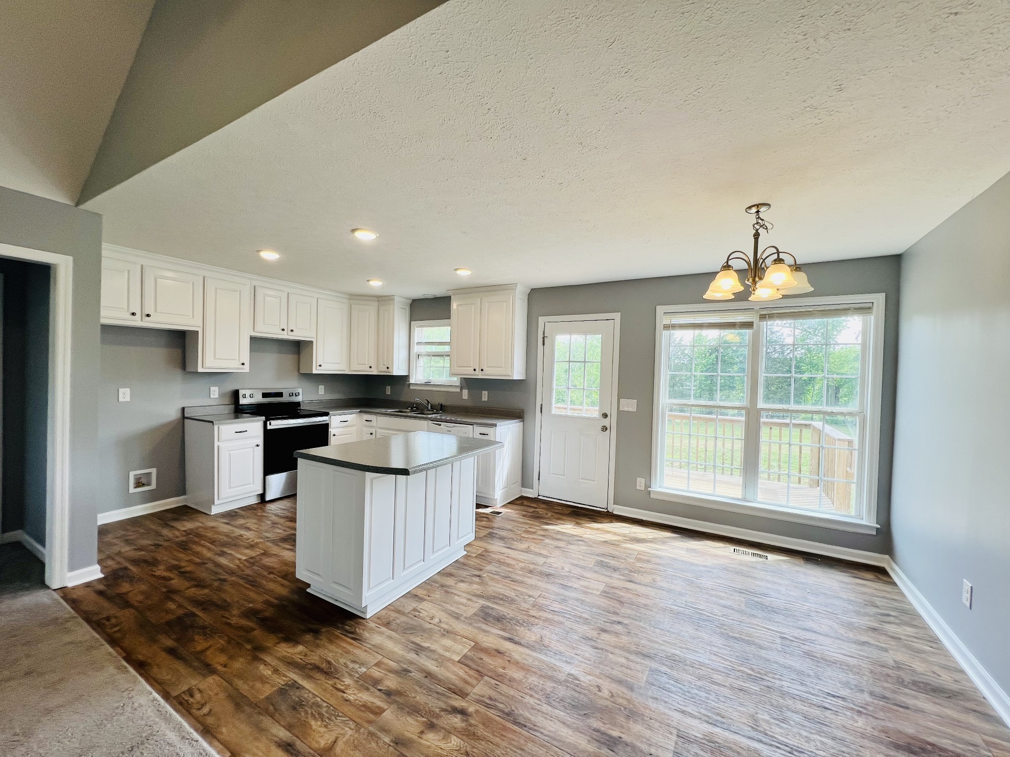 4861 Little Dry Creek Road Pulaski, TN 38478 - Photo 9 of 30 a open kitchen with granite countertop a stove top oven a sink dishwasher a dining table and chairs with wooden floor