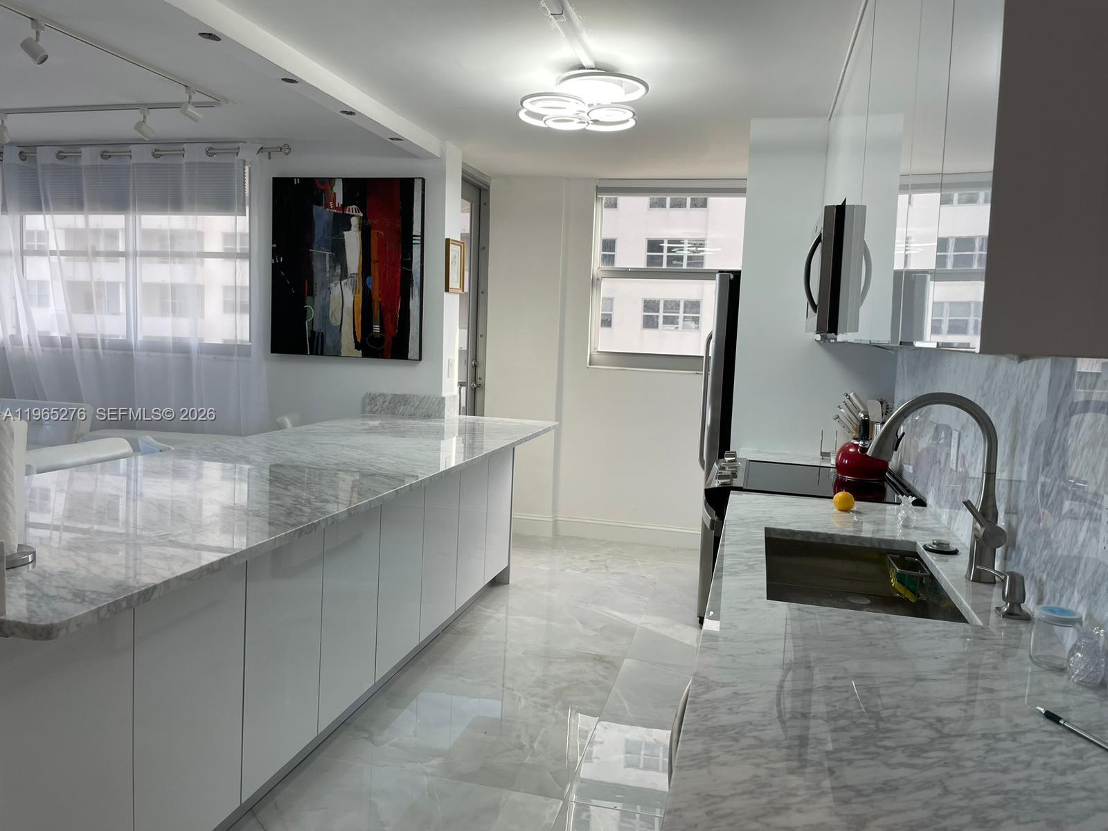 9273 Collins Avenue, Unit 412 Surfside, FL 33154 - Photo 3 of 10 a kitchen with stainless steel appliances granite countertop a sink and a stove