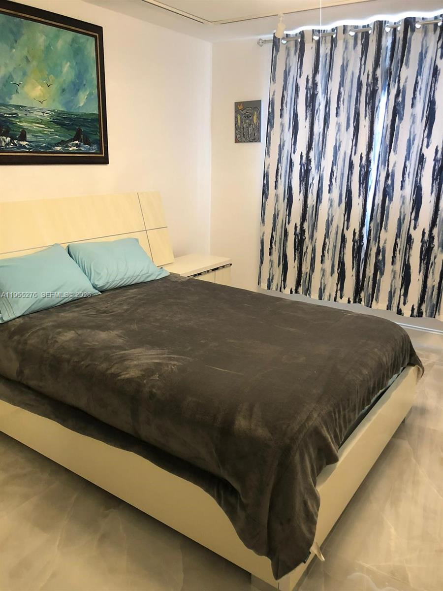 9273 Collins Avenue, Unit 412 Surfside, FL 33154 - Photo 7 of 10 a bedroom with a bed and painting on the wall