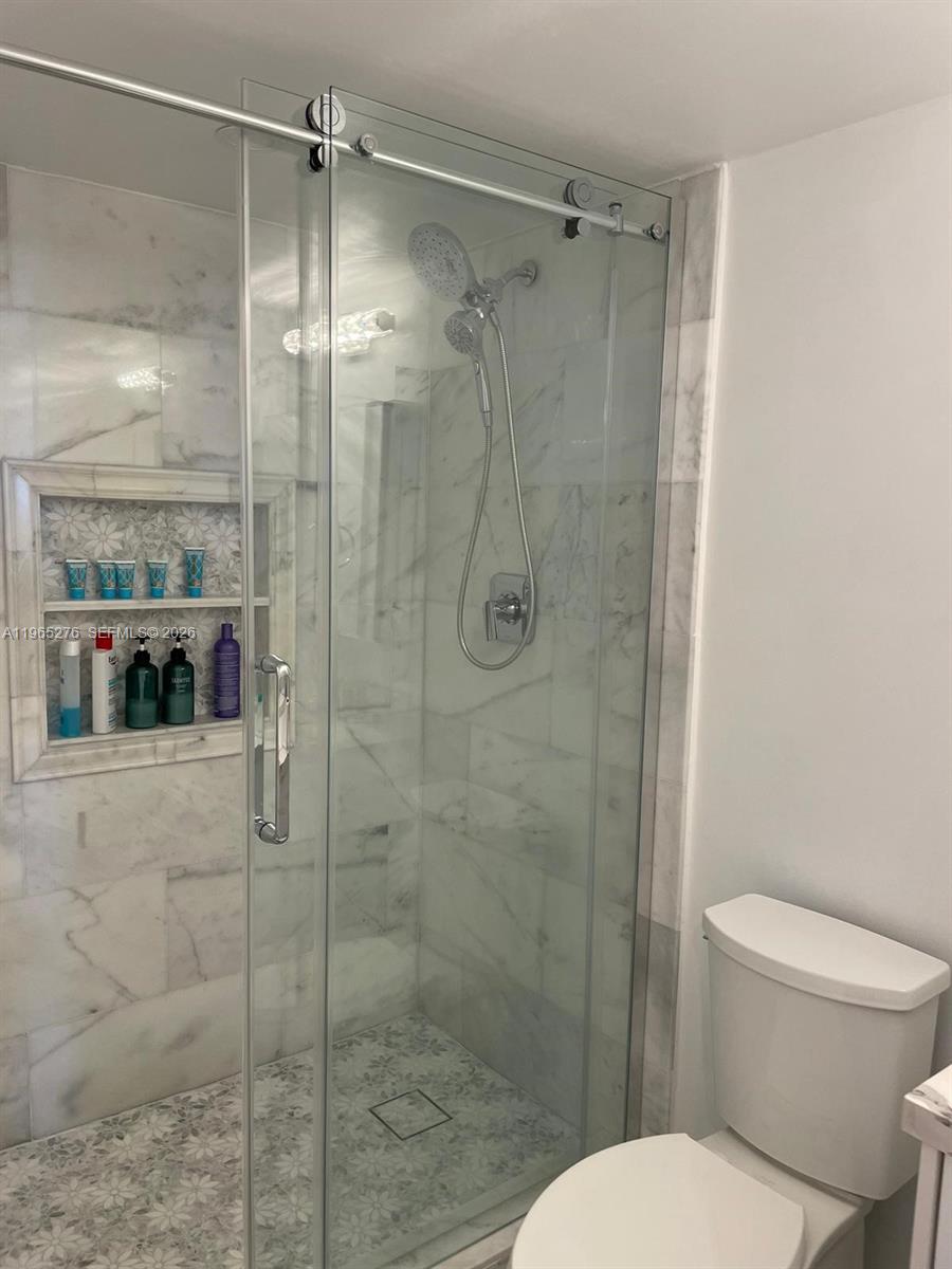 9273 Collins Avenue, Unit 412 Surfside, FL 33154 - Photo 8 of 10 a bathroom with a shower and toilet