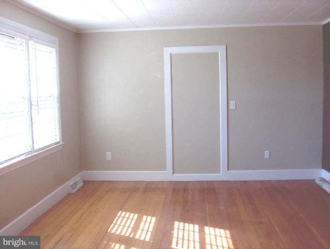 48680 Trapp Road St. Inigoes, MD 20684 - Photo 10 of 13 an empty room with wooden floor and windows