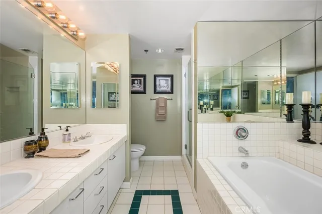 a en suite bathroom with a tub shower and mirror