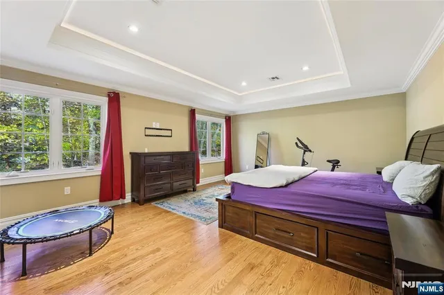 a spacious bedroom with a bed and a flat screen tv