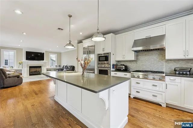 a kitchen with granite countertop white cabinets and white stainless steel appliances with a window