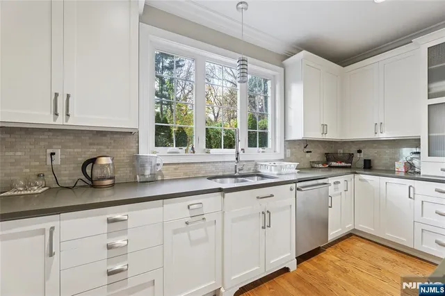 a kitchen with stainless steel appliances kitchen island granite countertop a sink and dishwasher a stove with wooden floor