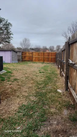 a view of a yard with wooden fence