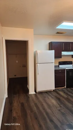 a utility room with wooden floor washer and dryer