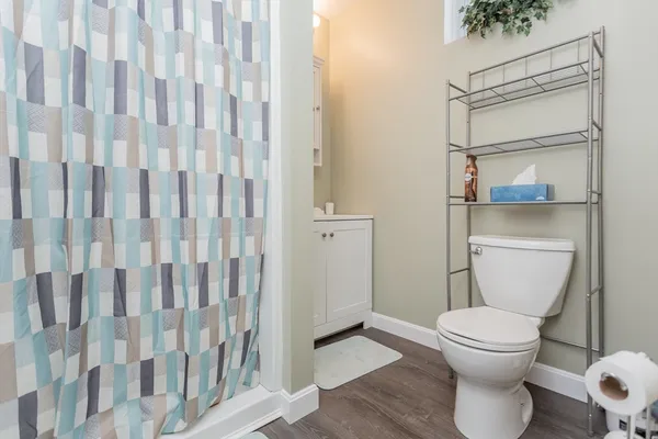 a bathroom with a toilet and a shower curtain
