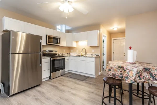 a kitchen with kitchen island white cabinets and stainless steel appliances