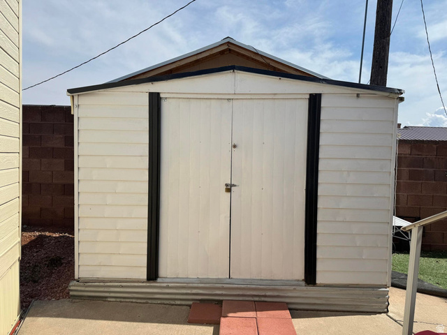 1225 North Dixie Downs Road, Unit 100 St. George, UT 84770 - Photo 22 of 22 Freestanding storage shed featuring a gabled roof, double entry doors, horizontal siding, and a corrugated metal base