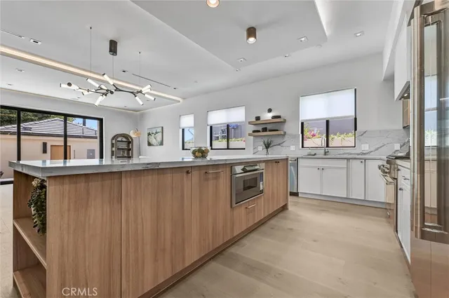 a kitchen with stainless steel appliances granite countertop a sink window and cabinets